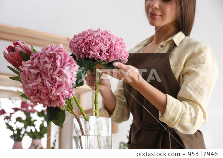 Florist with beautiful flowers in workshop, closeup 95317946
