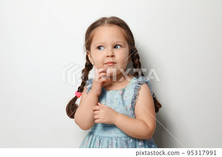 Cute little girl on light grey background Cute little girl on light grey background 95317991