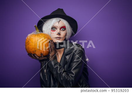 Scared surprised witch with grey hair on Halloween 95319203