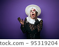 Scared whispering woman with grey hair in Halloween costume 95319204