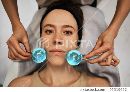Facial massage with cold spheres. Facial massage with cold spheres. 95319632
