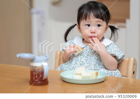 A 1-year-old girl who grabs and eats bread 95320009