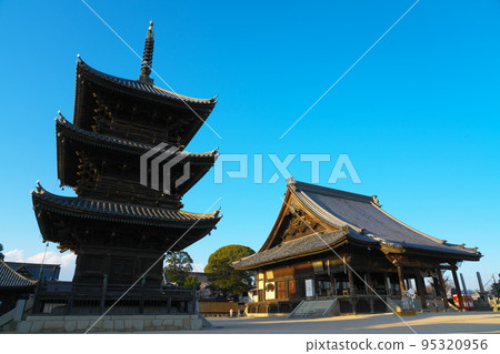 [Chugoku Sanjusan Kannon Sacred Site] No. 1 Saidaiji Main Hall and Three-storied Pagoda 2, Higashi Ward, Okayama City, Okayama Prefecture, Illuminated by the Spring Sunset 95320956
