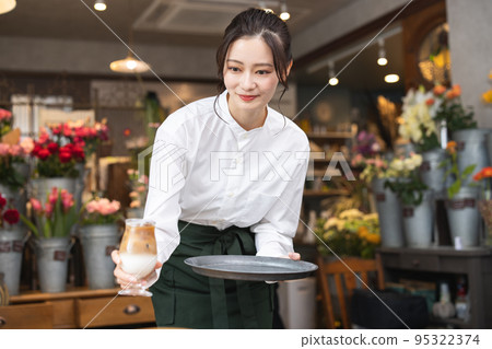 A young woman working in a cafe 95322374