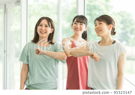 身著運動服的亞洲女性在健身房做肘部觸摸 95323147