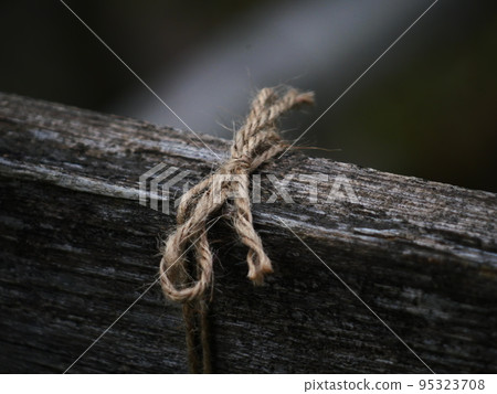 string tied to a wooden board 95323708