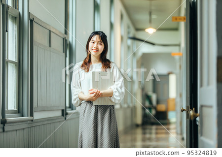 A woman walking in the corridor with a smile hall 95324819