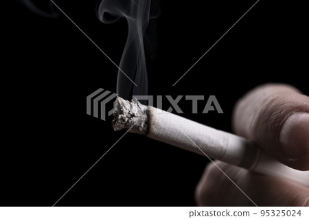 Cigarette in hand of a smoking man Cigarette in hand of a smoking man 95325024