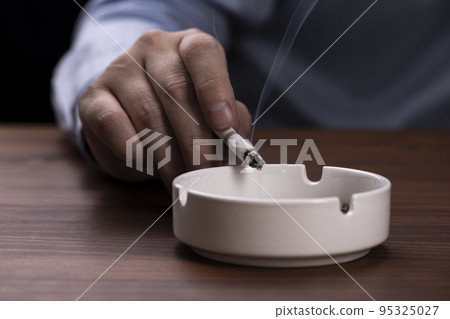 Cigarette in hand of a smoking man 95325027