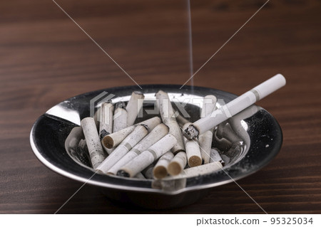 Forgot to extinguish the cigarette left in the ashtray Forgot to extinguish the cigarette left in the ashtray 95325034