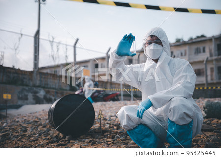 Scientist or Biologist in a protective suit and protect mask collects sample of waste water from industrial for analyze 95325445