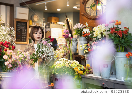 Young woman working in a flower shop 95325588