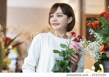 在花店挑選鮮花的年輕女子 在花店挑選鮮花的年輕女子 95325595