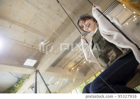 Young woman sitting on an indoor swing home camp home camp camp image 95327916