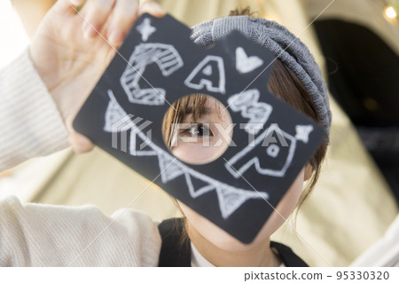 一位年輕女子坐在吊床上展示字母 一位年輕女子坐在吊床上展示字母 95330320