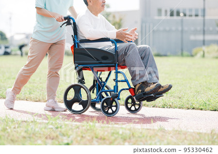 推擠輪椅的照料者和老人 95330462