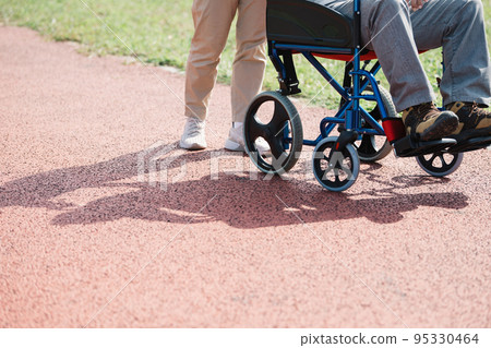 推擠輪椅的照料者和老人 推擠輪椅的照料者和老人 95330464