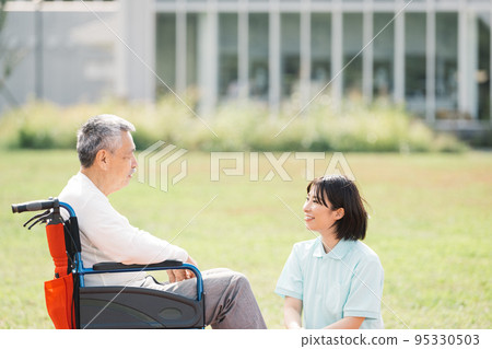 照顧者微笑著工作/女性照顧者與坐在輪椅上的男人交談 照顧者微笑著工作/女性照顧者與坐在輪椅上的男人交談 95330503