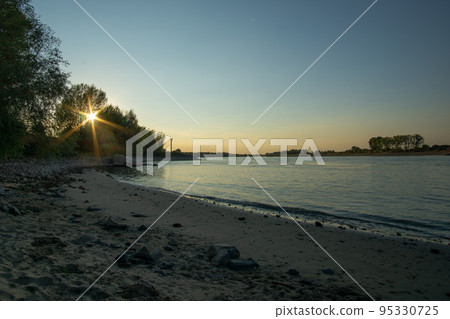 Sand beach on the Rhine in the evening light Sand beach on the Rhine in the evening light 95330725