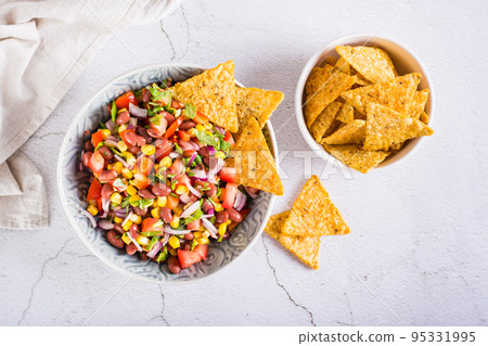 Mexican vegetable salad cowboy caviar and nachos in a bowl on the table. Top view Mexican vegetable salad cowboy caviar and nachos in a bowl on the table. Top view 95331995