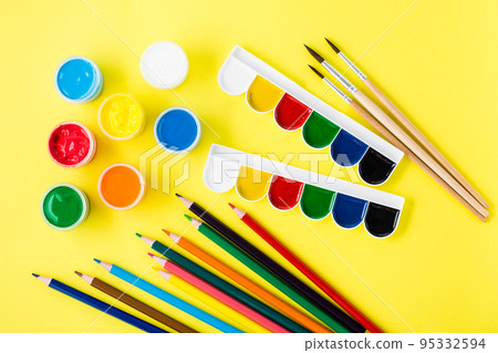 Painting tools. Gouache, watercolors, pencils and brushes on a yellow background. Creative leisure Painting tools. Gouache, watercolors, pencils and brushes on a yellow background. Creative leisure 95332594
