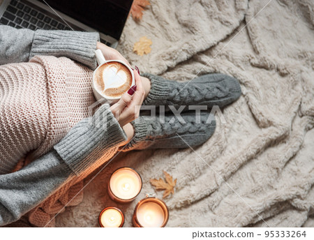 Cozy home, woman covered with warm blanket, drinks coffee. Cozy home, woman covered with warm blanket, drinks coffee. 95333264