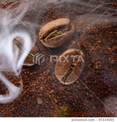 Ground coffee and coffee beans, coffee in light smoke. Ground coffee and coffee beans, coffee in light smoke. 95334003