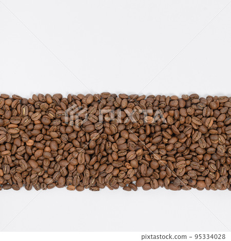 Coffee beans laid out in one wide row on a white background, place for inscription and advertising. Coffee beans laid out in one wide row on a white background, place for inscription and advertising. 95334028