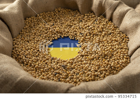 Burlap sack with soybeans and Ukrainian flag concept 95334715