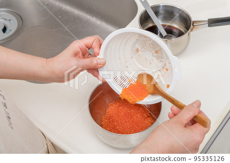 [將洗淨的三文魚子倒入碗中] 95335126