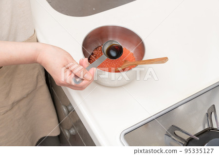 [將洗淨的三文魚子浸泡在醬汁中] 95335127