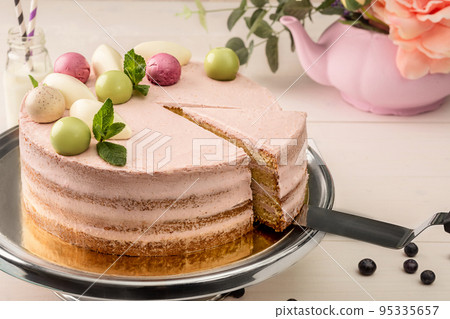 Sponge cake with berry cream garnished with balls of glazed chocolate, mousse and fresh mint Sponge cake with berry cream garnished with balls of glazed chocolate, mousse and fresh mint 95335657