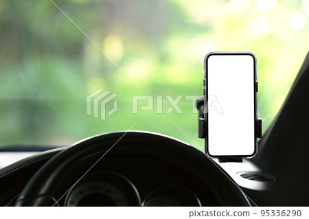 Mobile phone on universal mount holder in car for GPS. Blank screen for advertise design 95336290