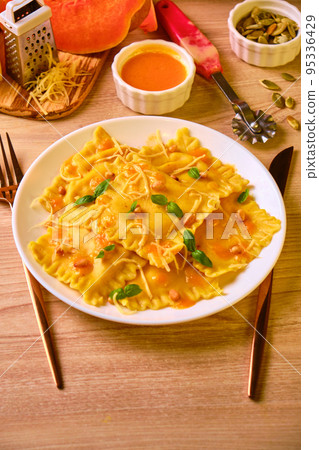 Homemade Pumpkin Ravioli with ricotta cheese served basil 95336429
