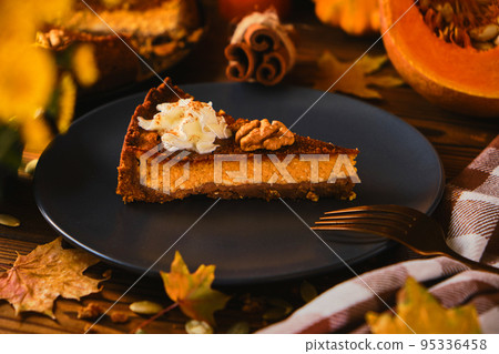 Homemade pumpkin cheesecake decorated with whipped cream Homemade pumpkin cheesecake decorated with whipped cream 95336458