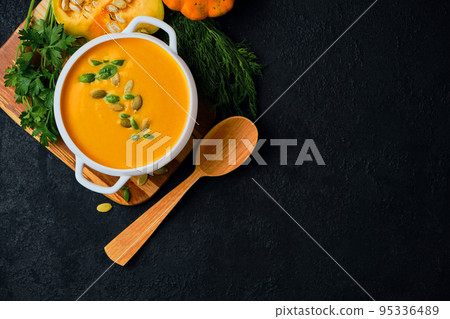 Pumpkin cream soup with pumpkin seeds served 95336489