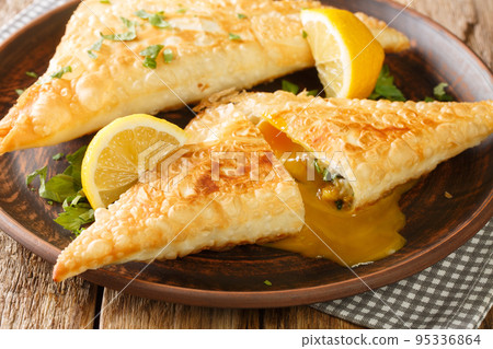 Brik or burek is the north African version of borek, a stuffed filo pastry which is commonly deep fried close up in the plate. Horizontal 95336864