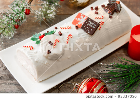White chocolate yule log cake with christmas ornament isolated on white background 95337056