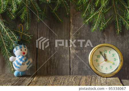 Clock and snowman under the Christmas tree on a wooden background Clock and snowman under the Christmas tree on a wooden background 95338067