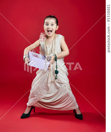 little black-haired fashionista in high-heeled shoes. funny photo shoot in the studio on a red background little black-haired fashionista in high-heeled shoes. funny photo shoot in the studio on a red background 95338881