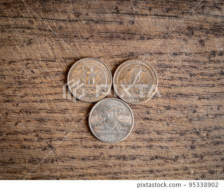 Close up of quarter dollar coins. Financial concept on wooden background 95338902