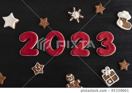 Inscription 2023 from gingerbread cookie. Christmas bacing, black background Inscription 2023 from gingerbread cookie. Christmas bacing, black background 95339661