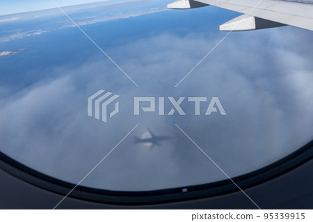 從飛機的窗戶看到的飛機陰影反映在雲層中的視圖 從飛機的窗戶看到的飛機陰影反映在雲層中的視圖 95339915