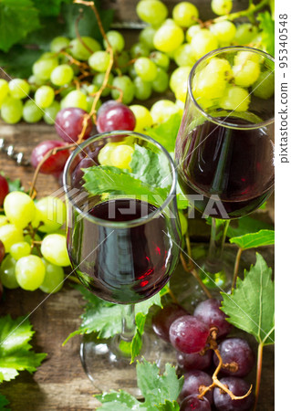 Wine background. Red wine in glasses, bottle, grapes on vintage background, wine concept. Wine background. Red wine in glasses, bottle, grapes on vintage background, wine concept. 95340548