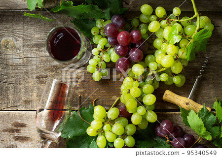 Wine background. Red wine in glasses, bottle, grapes on vintage background, wine concept. Copy space, top view flat lay background. Wine background. Red wine in glasses, bottle, grapes on vintage background, wine concept. Copy space, top view flat lay background. 95340549