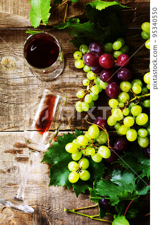 Wine background. Red wine in glasses, bottle, grapes on vintage background, wine concept. Copy space, top view flat lay background. Wine background. Red wine in glasses, bottle, grapes on vintage background, wine concept. Copy space, top view flat lay background. 95340550