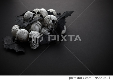Halloween concept - black bats and skulls on black background. Halloween concept - black bats and skulls on black background. 95340601