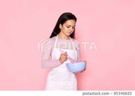 woman holding whisk and bowl with eggs woman holding whisk and bowl with eggs 95340685