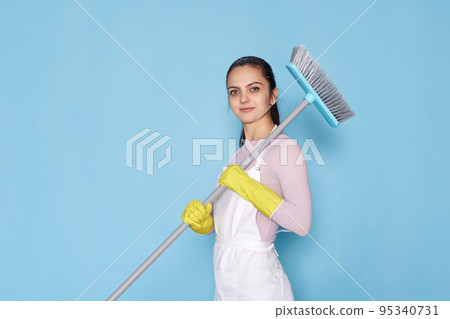 woman in gloves and cleaner apron holding broom woman in gloves and cleaner apron holding broom 95340731