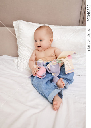 baby girl play with own socks in bedroom 95340803